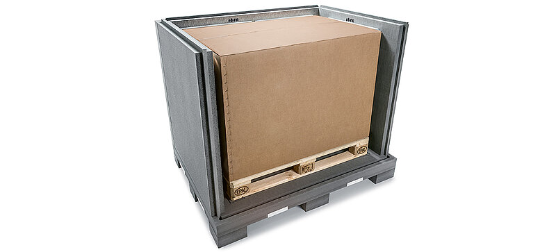 A black insulated container with an inner carton and cooling elements on a pallet
